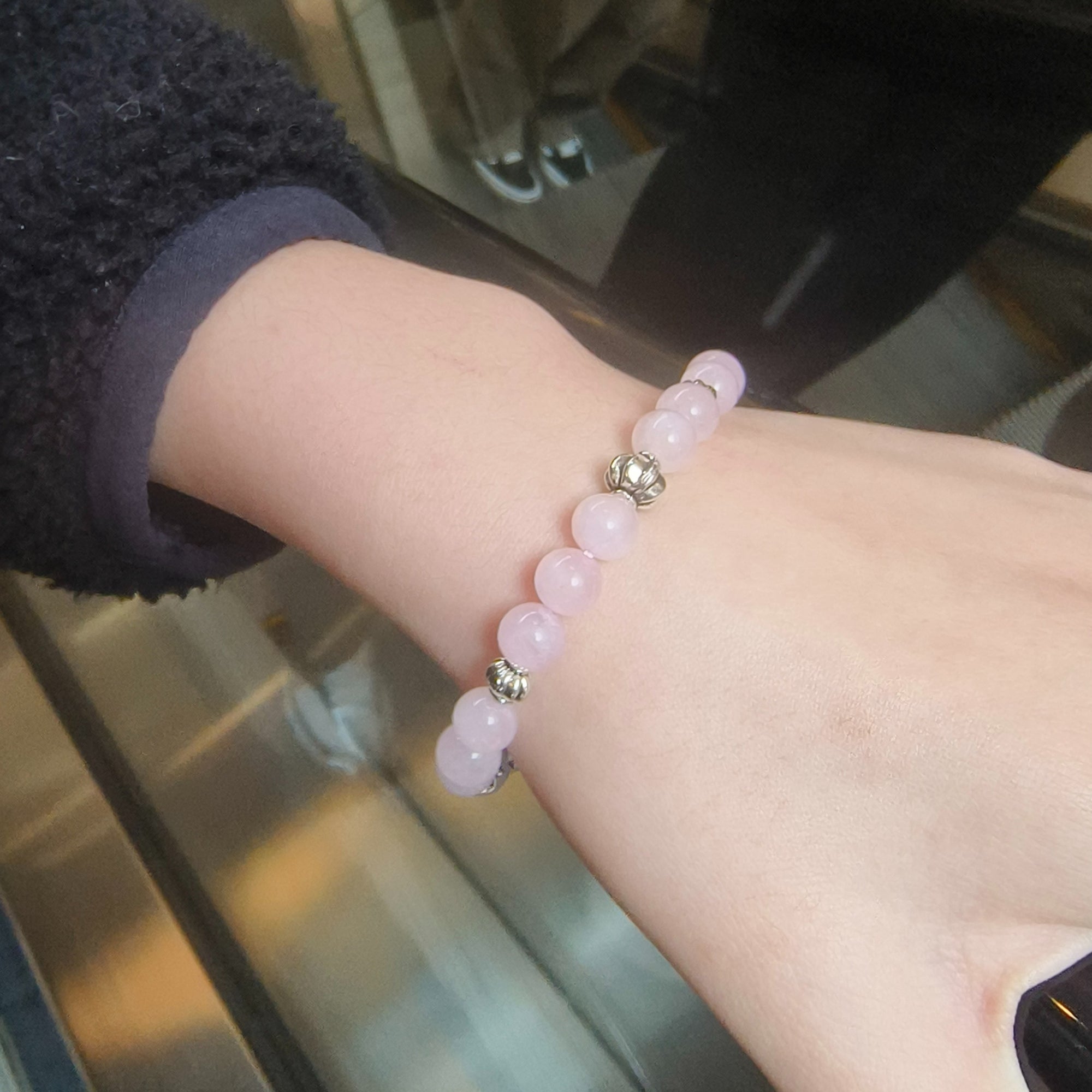 LIORA Love Bracelet - Rose Quartz worn on hand in a shopping center