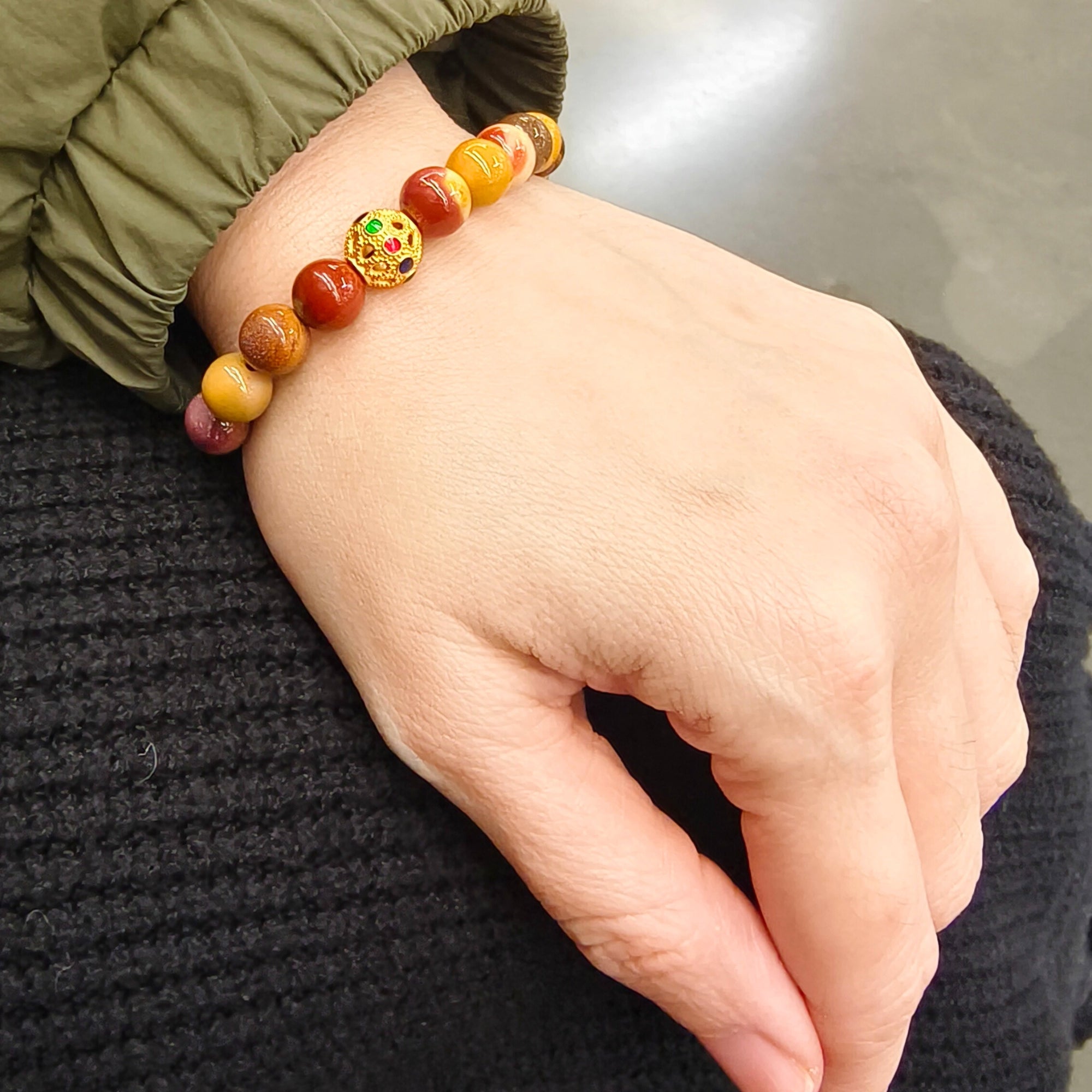MIRA Health Bracelet – Mookaite worn on wrist in a shopping center